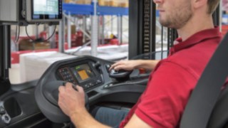Сотрудник управляет многофункциональным рычагом в погрузчике Linde Material Handling