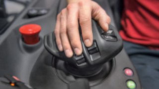 Рука водителя штабелёра покоится на многофункциональном рычаге от Linde Material Handling